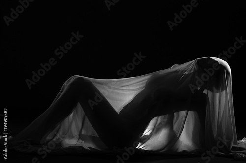 sensual sexy look of beautiful figure girl under hiding in light thin fabric, to show silhouette of woman body lying on floor