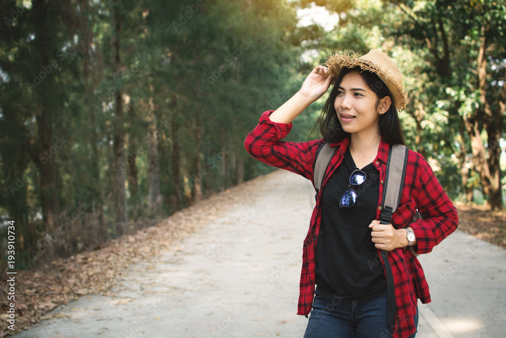 Woman backpacker in the road and forest background, Relax time on holiday concept travel ,color of vintage tone and soft focus Woman backpacker in the road and forest background, Relax time on holiday concept travel ,color of vintage tone and soft focus