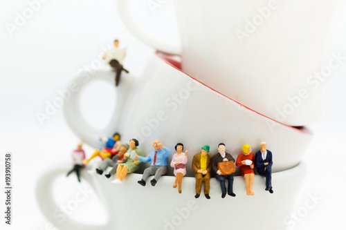 Miniature people : Business team sitting on cup of coffee and having a coffee break. Image use for business concept.