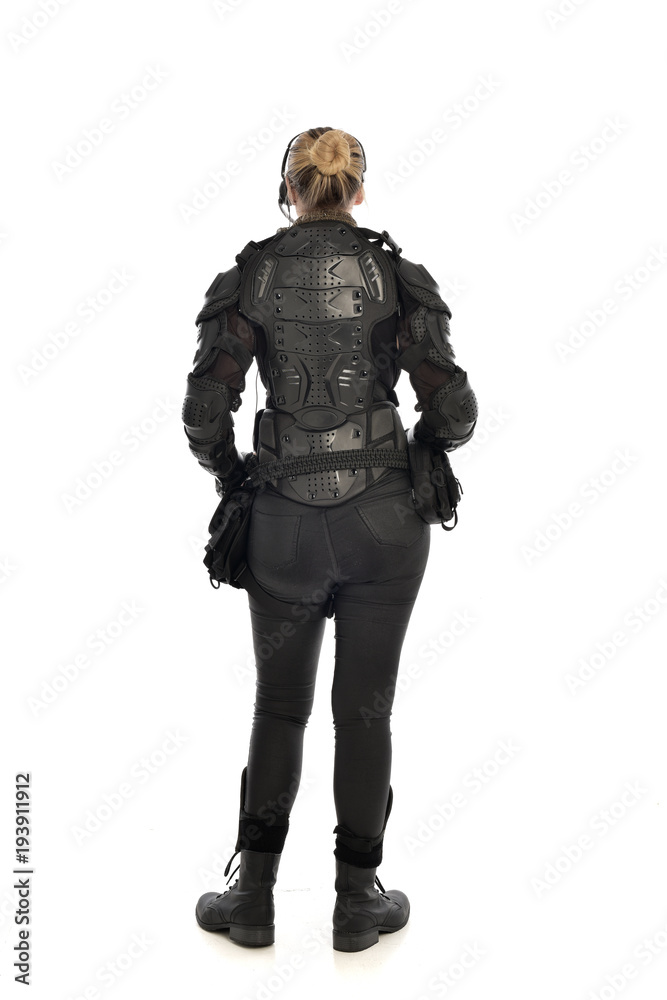 full length portrait of female  soldier wearing black  tactical armour  facing away from camera, isolated on white studio background.