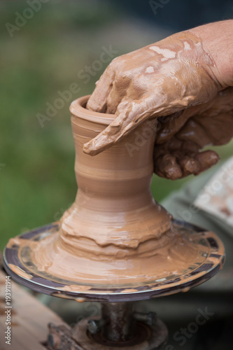 Create vases from clay close up. Hands of a master make a clay pitcher on a Potter's wheel.