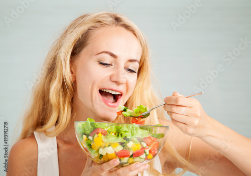 Young woman preparing vegetable salad
