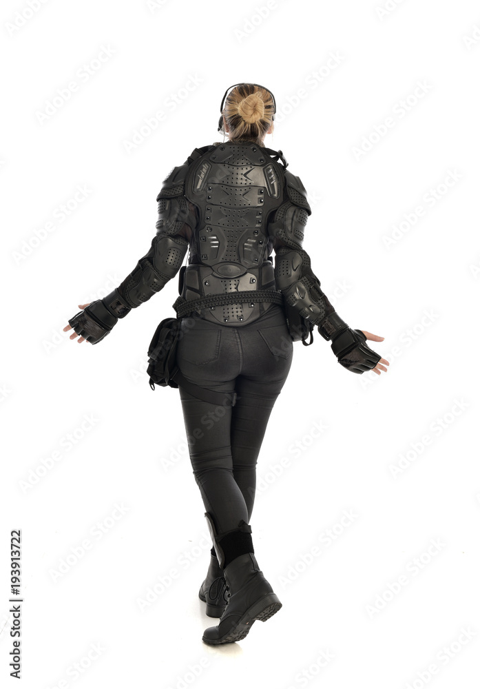 full length portrait of female  soldier wearing black  tactical armour  facing away from camera, isolated on white studio background.