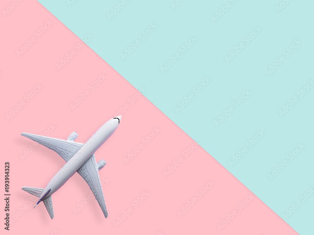 flat lay of white plane model on pastel blue and pink color background with copy space. travel and vacation concept