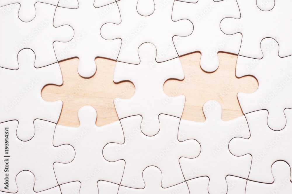 White blank puzzle with 2 pieces missing on wooden board with copy space.  Stock Photo | Adobe Stock