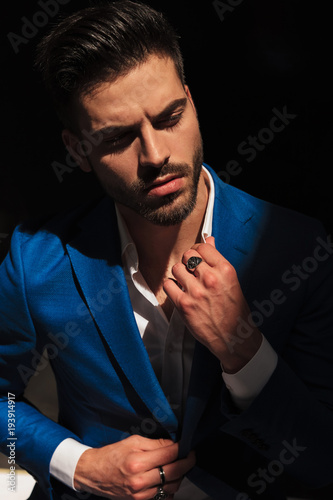 dramatic sexy man holding collar and looks to side