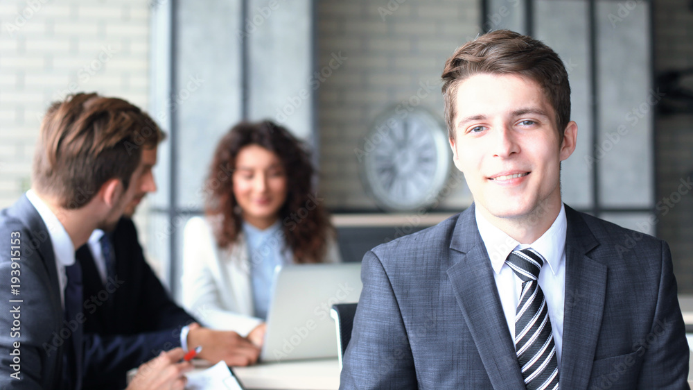 Businessman with colleagues in the background in office. Businessman with colleagues in the background in office.