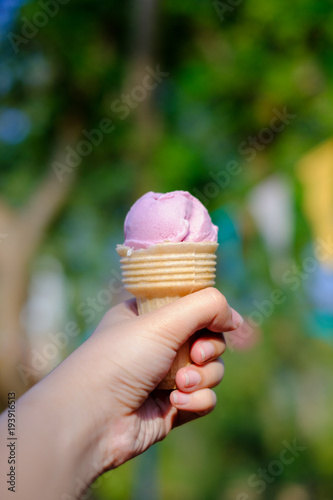 Pink ice cream cone in his left hand.