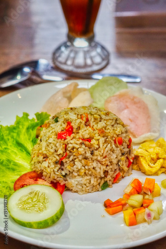 salted fish fried rice with a complement of crackers, omelet, pickled cucumber, and lettuce