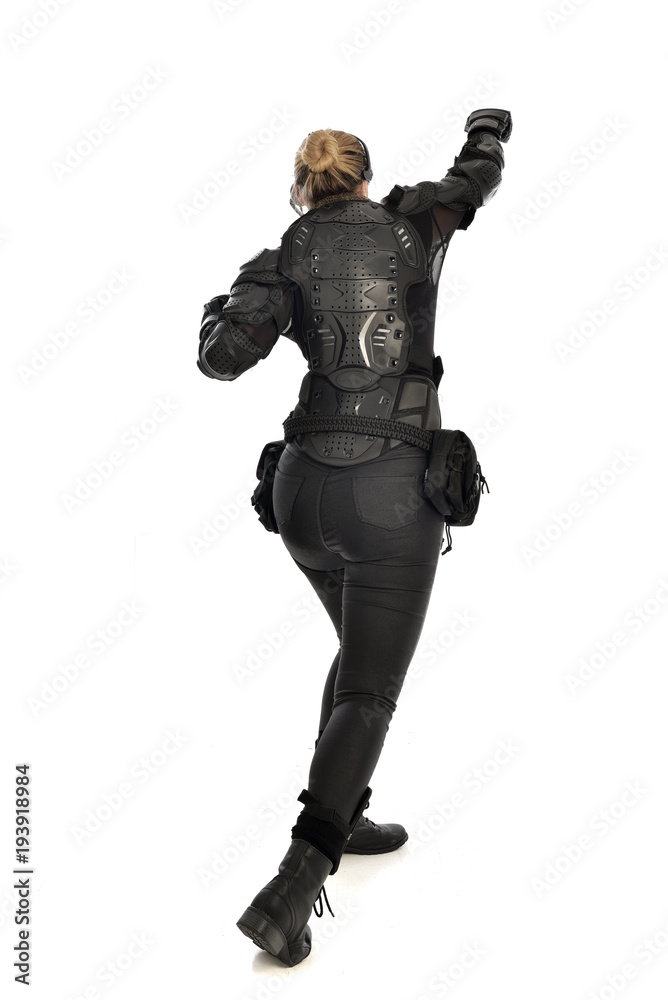 full length portrait of female  soldier wearing black  tactical armour  facing away from camera, isolated on white studio background.