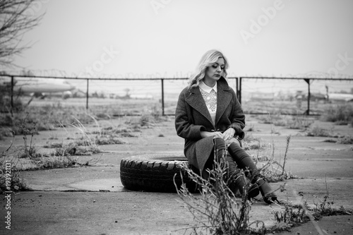 Retro style picture of a traveler in the old airport, girl in retro style wear vintage look 