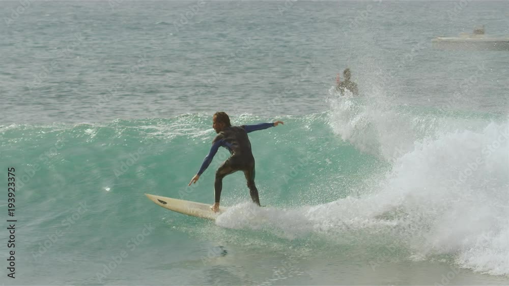 SLOW MOTION Extreme sports enthusiast enjoying his time surfing at Fuerteventura. Male surfer riding and breaking barrel wave glistening in the sun. Laidback dude clearing his head on his surfboard SLOW MOTION Extreme sports enthusiast enjoying his time surfing at Fuerteventura. Male surfer riding and breaking barrel wave glistening in the sun. Laidback dude clearing his head on his surfboard