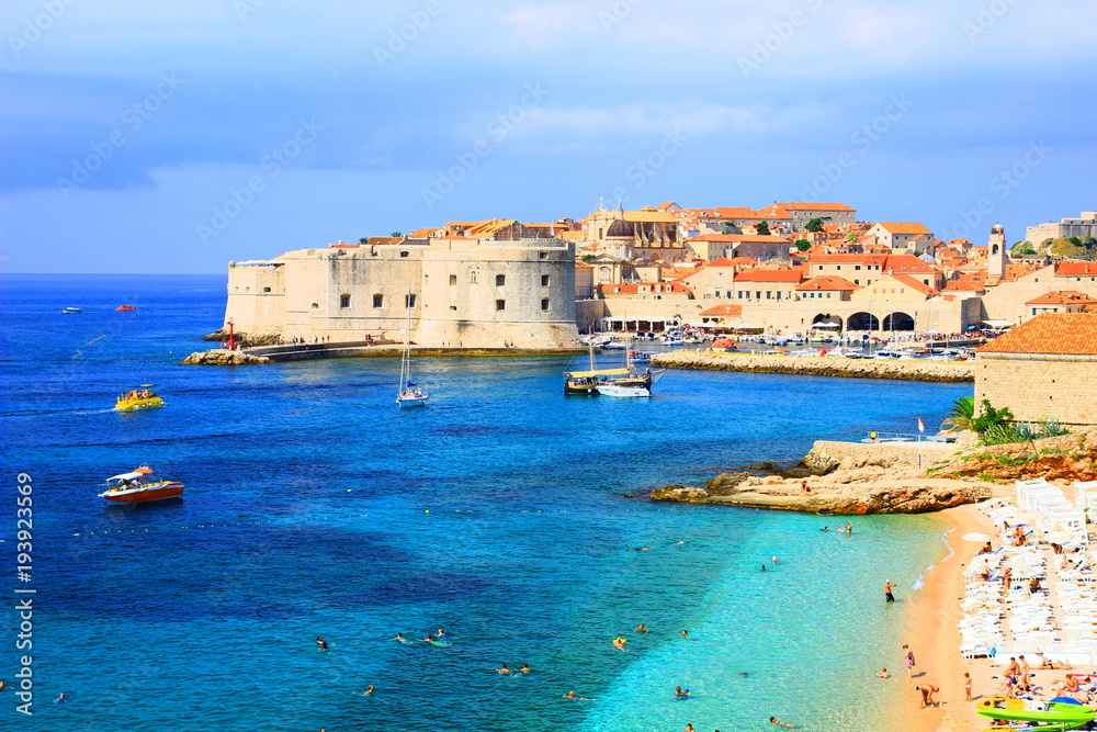 Dubrovnik, touristis destination in Croatia, panorama of old town and beautiful beach Banje with clear blue sea