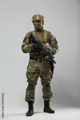 Full-length picture of military man in camouflage with gun © Sergey