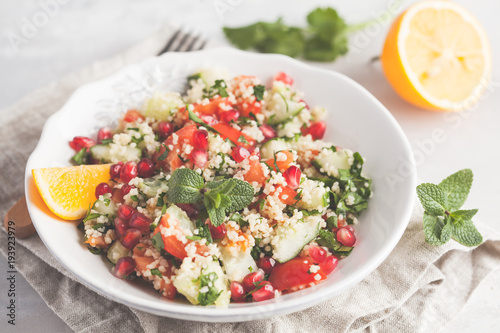 Tabbouleh salad with tomato, cucumber, couscous, mint and pomegranate. Vegan Healthy Food Concept. Traditional middle eastern or arab dish.