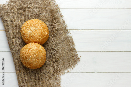 Several small multi grain triangular shaped bread sprinkled with whole sunflower seeds, flax and sesame seeds on a sackcloth photo