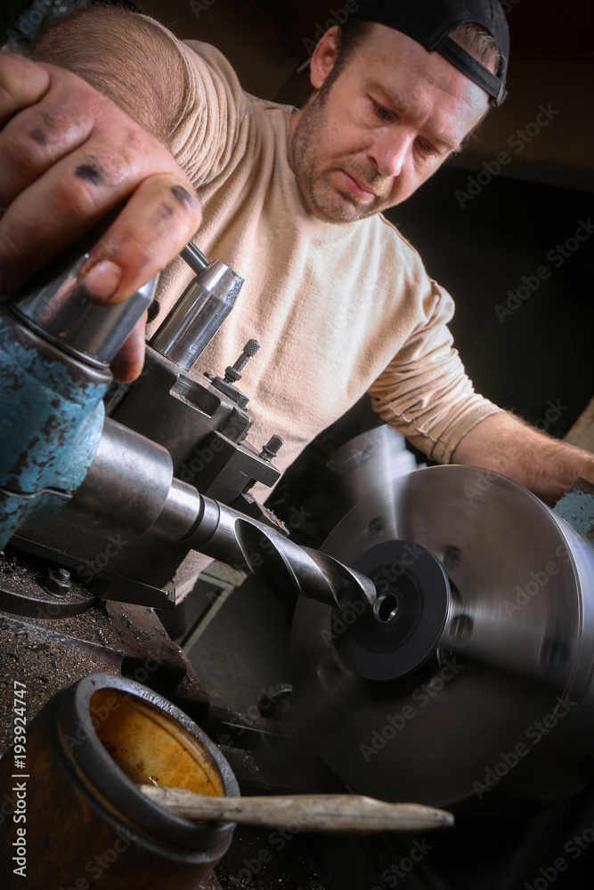 Metal worker working on lathe Metal worker working on lathe