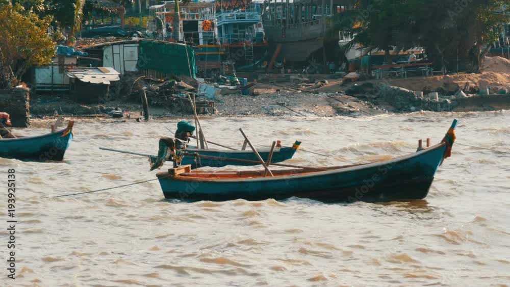 Small fishing boats sail along the lush sea on waves. Fishermen catch fish in the sea Small fishing boats sail along the lush sea on waves. Fishermen catch fish in the sea