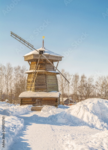 Rural winter landscape with an old wooden windmill
