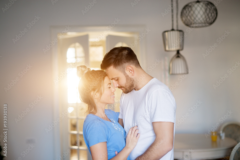 Εκτύπωση καμβά Young beautiful couple in love cuddling gently in pajamas at home