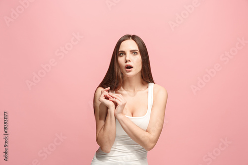 Beautiful woman looking suprised isolated on pink
