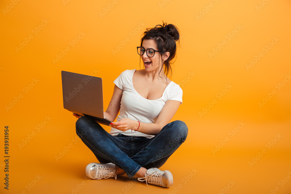 Fotografie Cheerful pretty young woman using laptop computer.