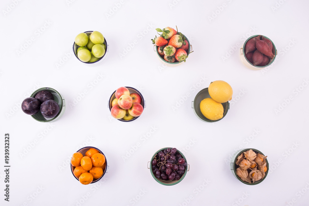 Bowls of various kinds of fruits laying over white background - creative health concept