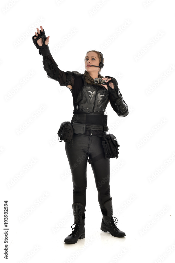 full length portrait of female soldier wearing black tactical armour holding a pair of binoculars, isolated on white studio background. full length portrait of female soldier wearing black tactical armour holding a pair of binoculars, isolated on white studio background.