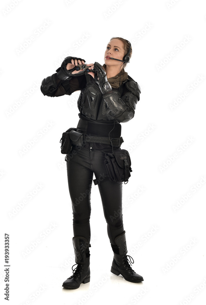 full length portrait of female soldier wearing black tactical armour holding a pair of binoculars, isolated on white studio background. full length portrait of female soldier wearing black tactical armour holding a pair of binoculars, isolated on white studio background.