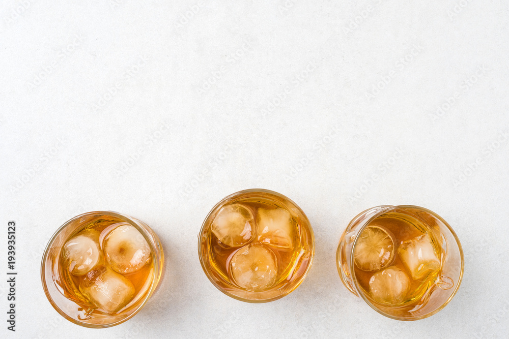 Whiskey glasses with ice cubes on white background Whiskey glasses with ice cubes on white background