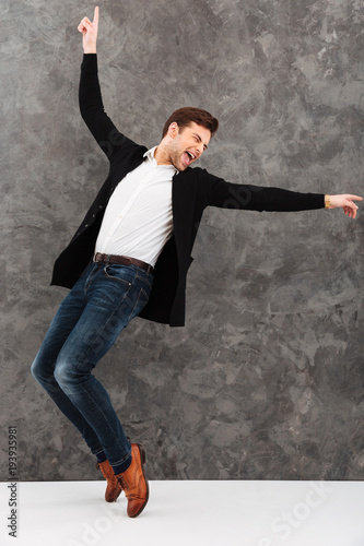 Excited young businessman dancing