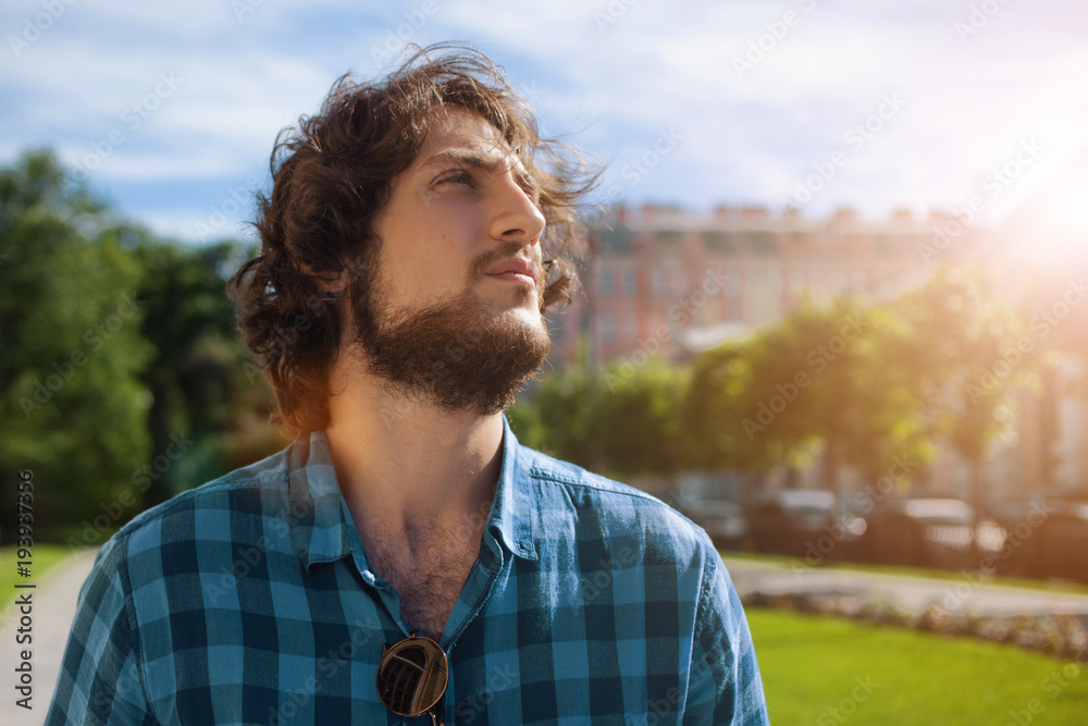 Portrait of young handsome stylish man on the street looking up. Portrait of young handsome stylish man on the street looking up.