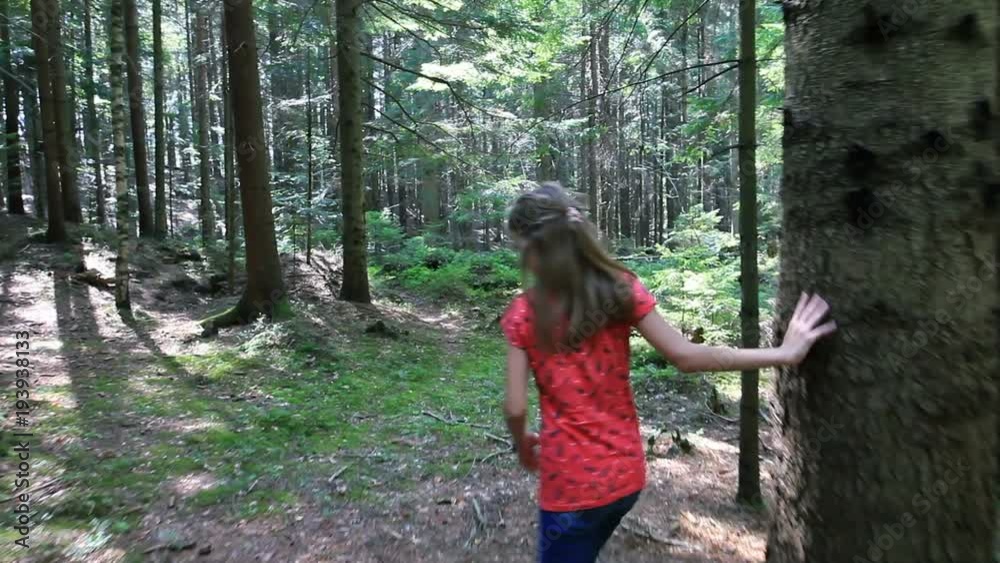 Little girl walks through forest on sunny day Little girl walks through forest on sunny day