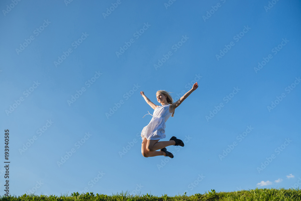 full lenth portrait of young woman is jumping on the meadow full lenth portrait of young woman is jumping on the meadow