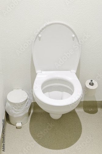 simple wc with toiletpaper and trash can in a budget hotel