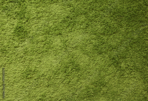 Green carpet. Surface imitating green grass. A close-up photograph. Top view 