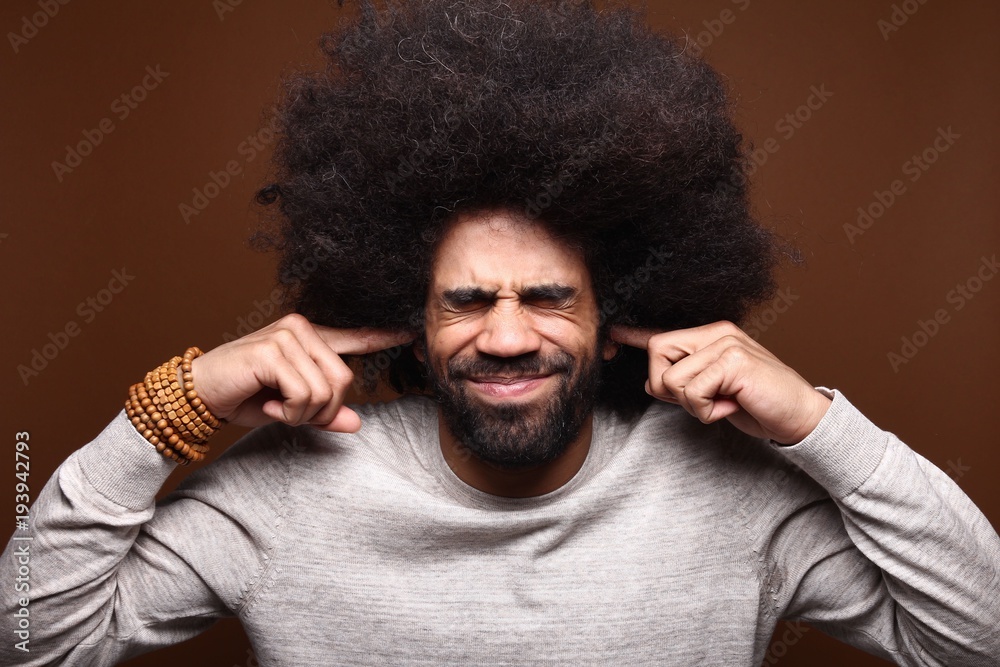 Afro man in front of a brown background