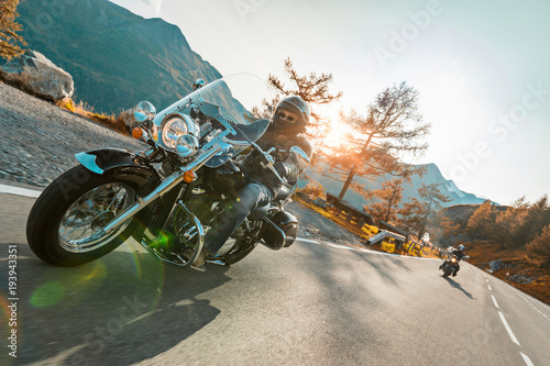 Motorcycle driver riding japanese high power cruiser in Alpine highway on famous Hochalpenstrasse, Austria. photo