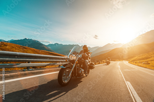 Motorcycle driver riding japanese high power cruiser in Alpine highway on famous Hochalpenstrasse, Austria. photo