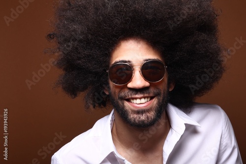 Afro man in front of a brown background