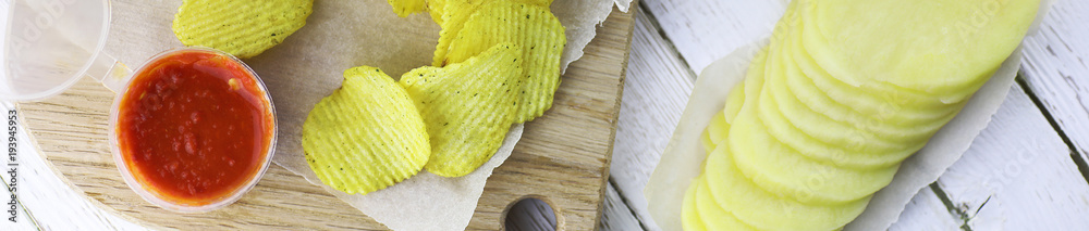 Horizontal bakground of potato chips on a table Horizontal bakground of potato chips on a table