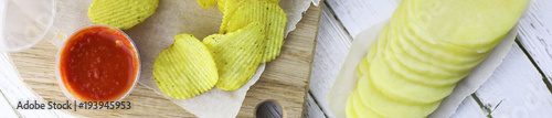 Horizontal bakground of potato chips on a table