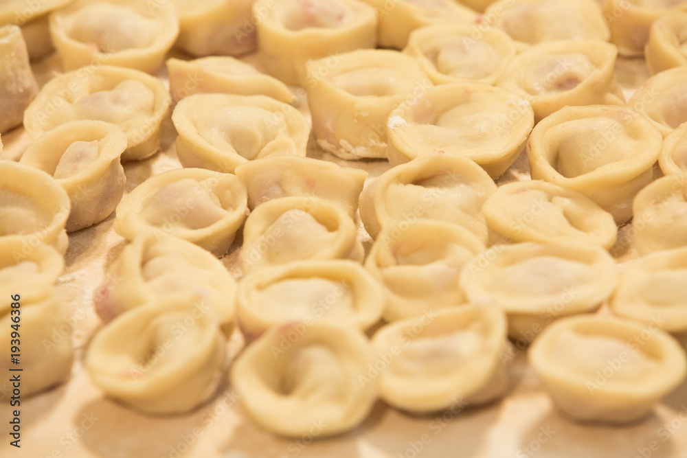 Preparing, cooking, making homemade ravioli, pelmeni or dumplings with meat on . close-up Preparing, cooking, making homemade ravioli, pelmeni or dumplings with meat on . close-up