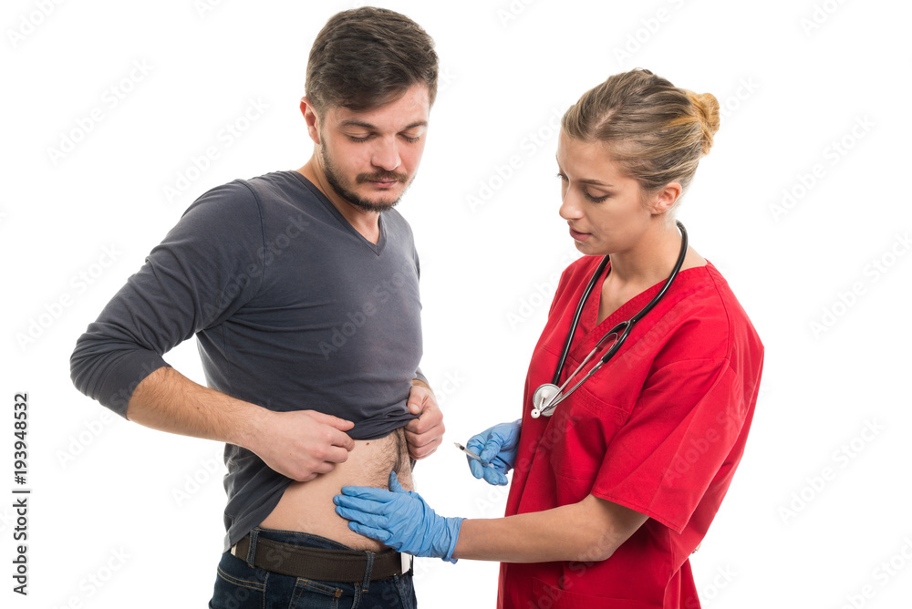 Attractive female doctor making injection to male patient.