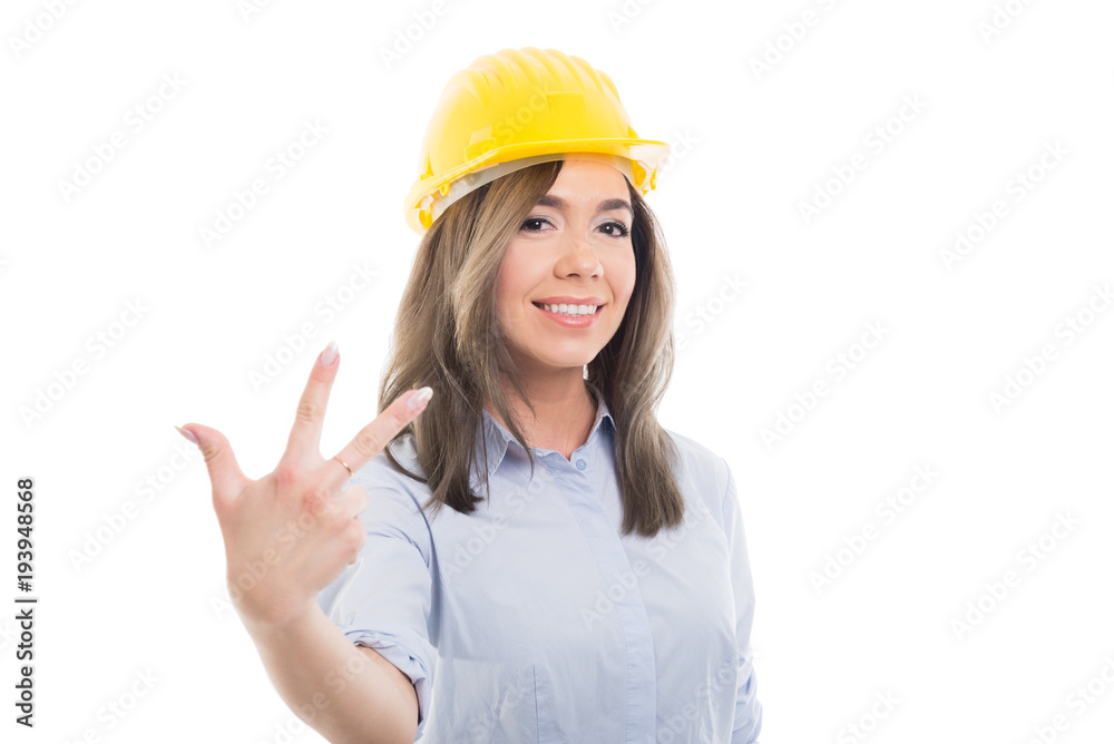 Portrait of female constructor showing number three. Portrait of female constructor showing number three.