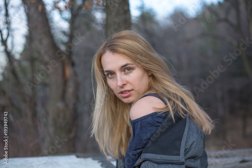 Beautiful natural young blonde woman wearing winter coat outside in the park winter time