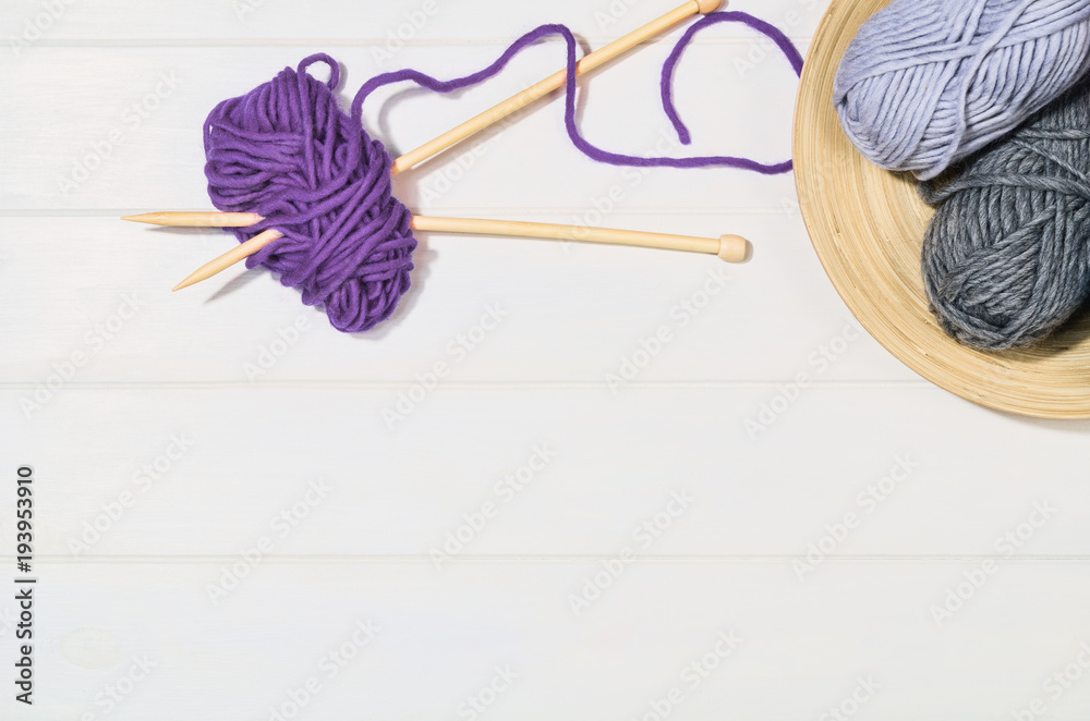 Top view of colorful knitting yarn balls and needlework accessories on white wooden textured table background. Photograph taken from above with copy space around products Top view of colorful knitting yarn balls and needlework accessories on white wooden textured table background. Photograph taken from above with copy space around products