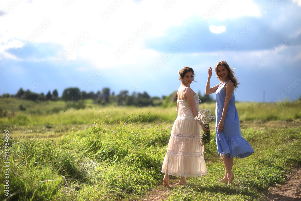 Young girls are walking in the field Young girls are walking in the field
