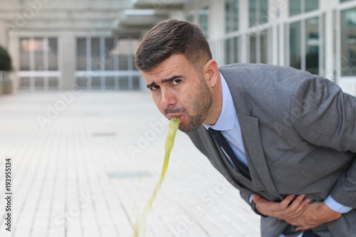 Overworked businessman vomiting at work  photo