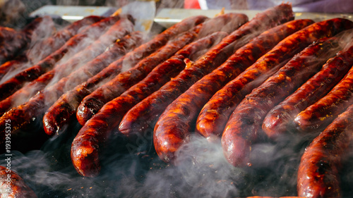 Fotografia Grilled sausage on barbecue, grill. Shallow depth of field.